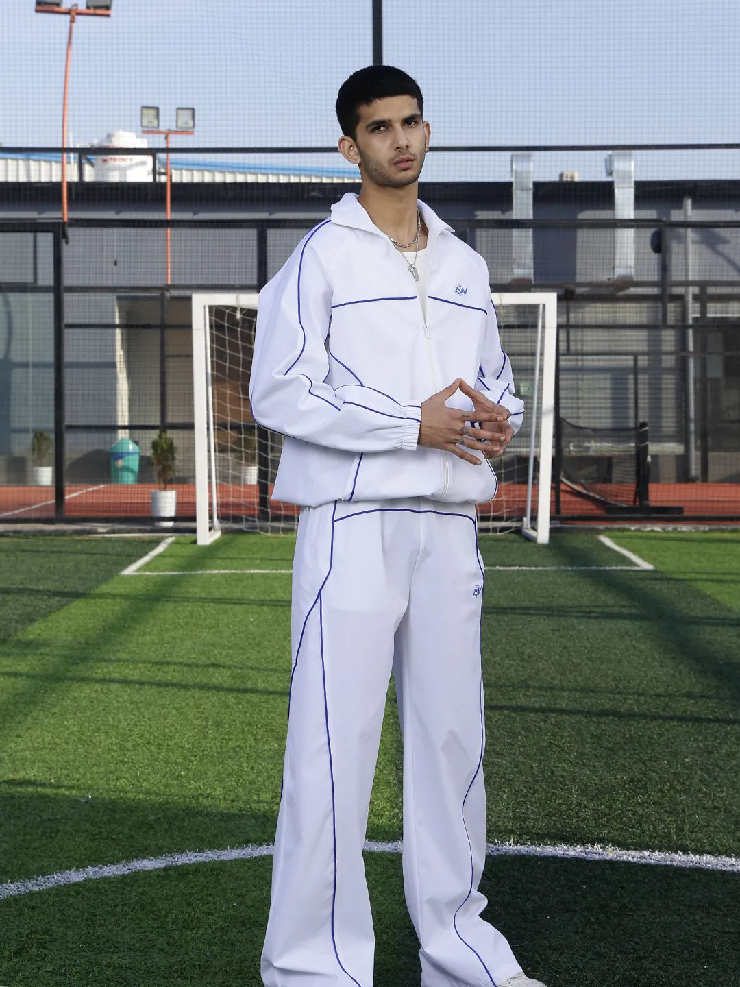 Person wearing a white tracksuit on a sports field