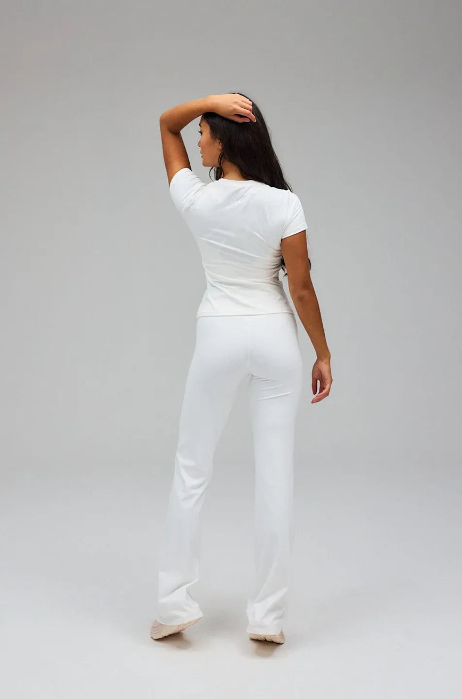 Person wearing a white outfit on a plain background