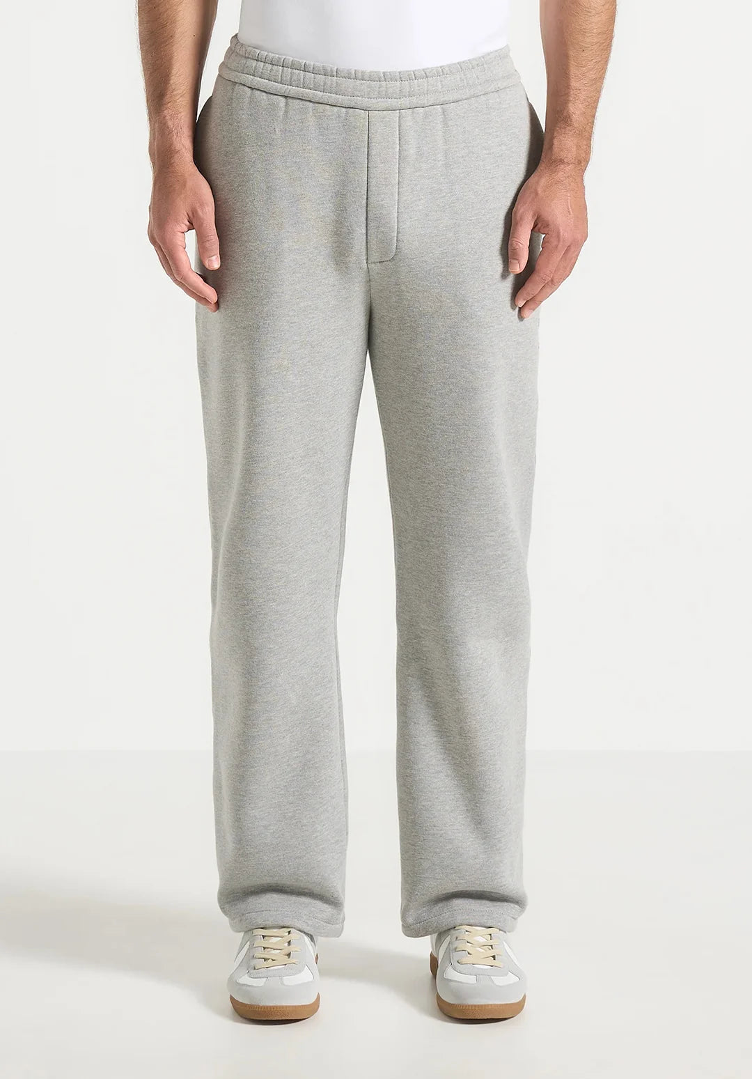 Person wearing gray sweatpants on a white background