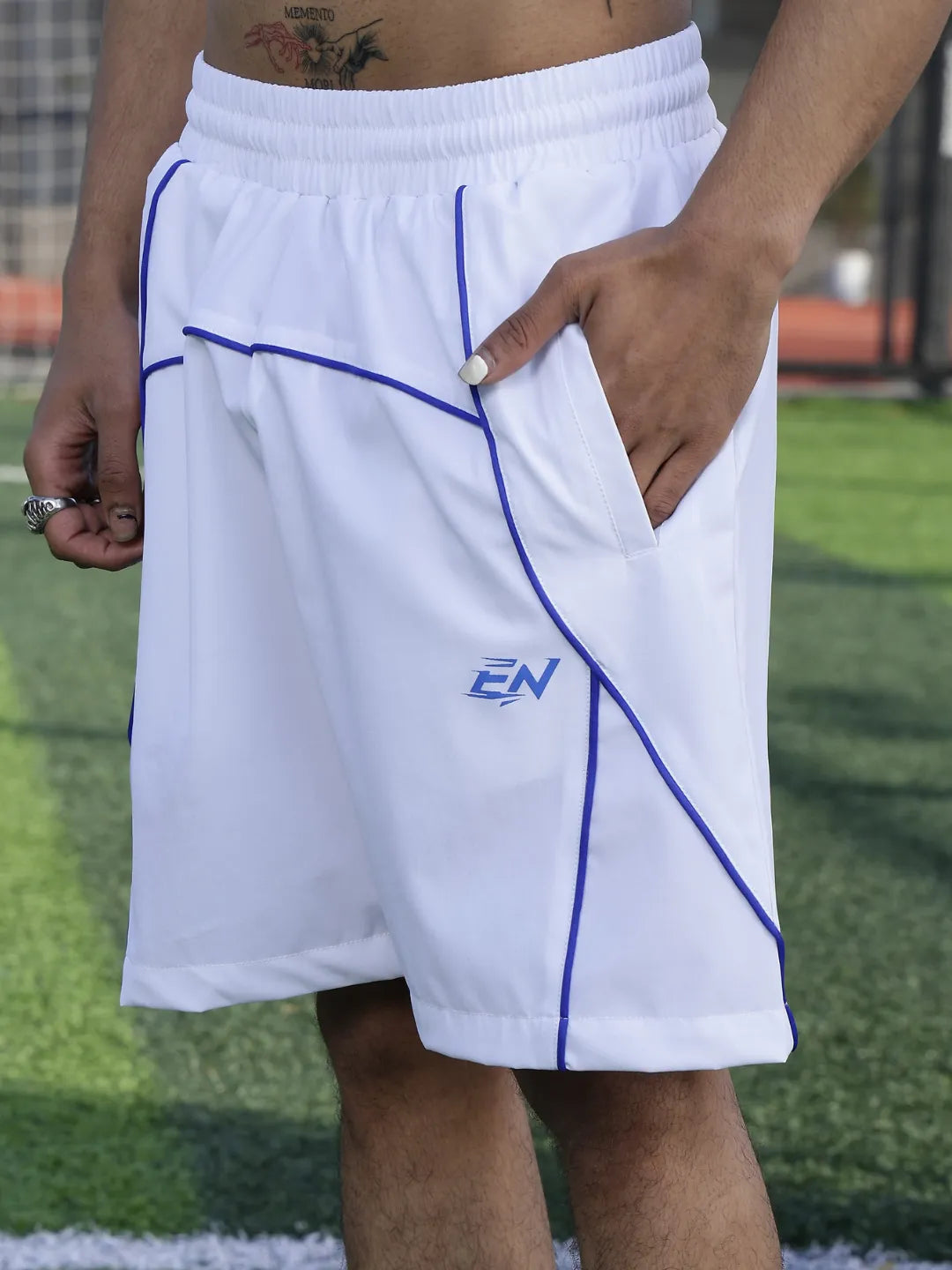 White shorts with blue lines and a logo on a grassy field