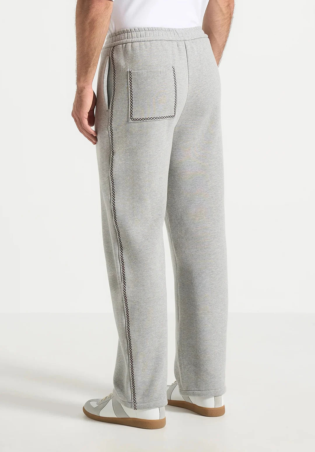 Person wearing gray sweatpants with a white background