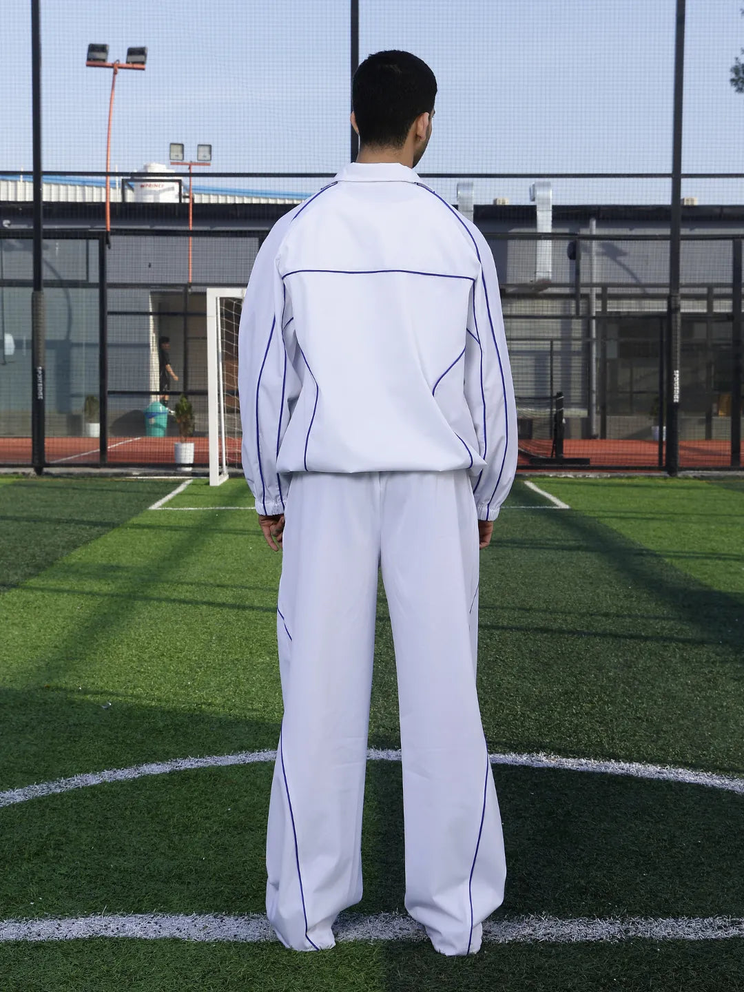 Person wearing a white tracksuit on a sports field