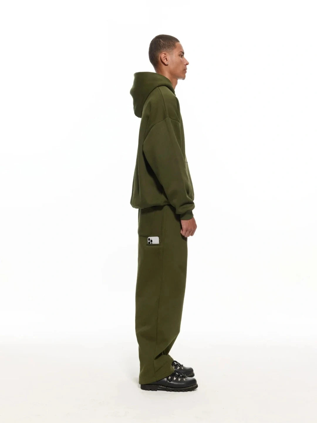 Person wearing a green tracksuit with a logo on a white background