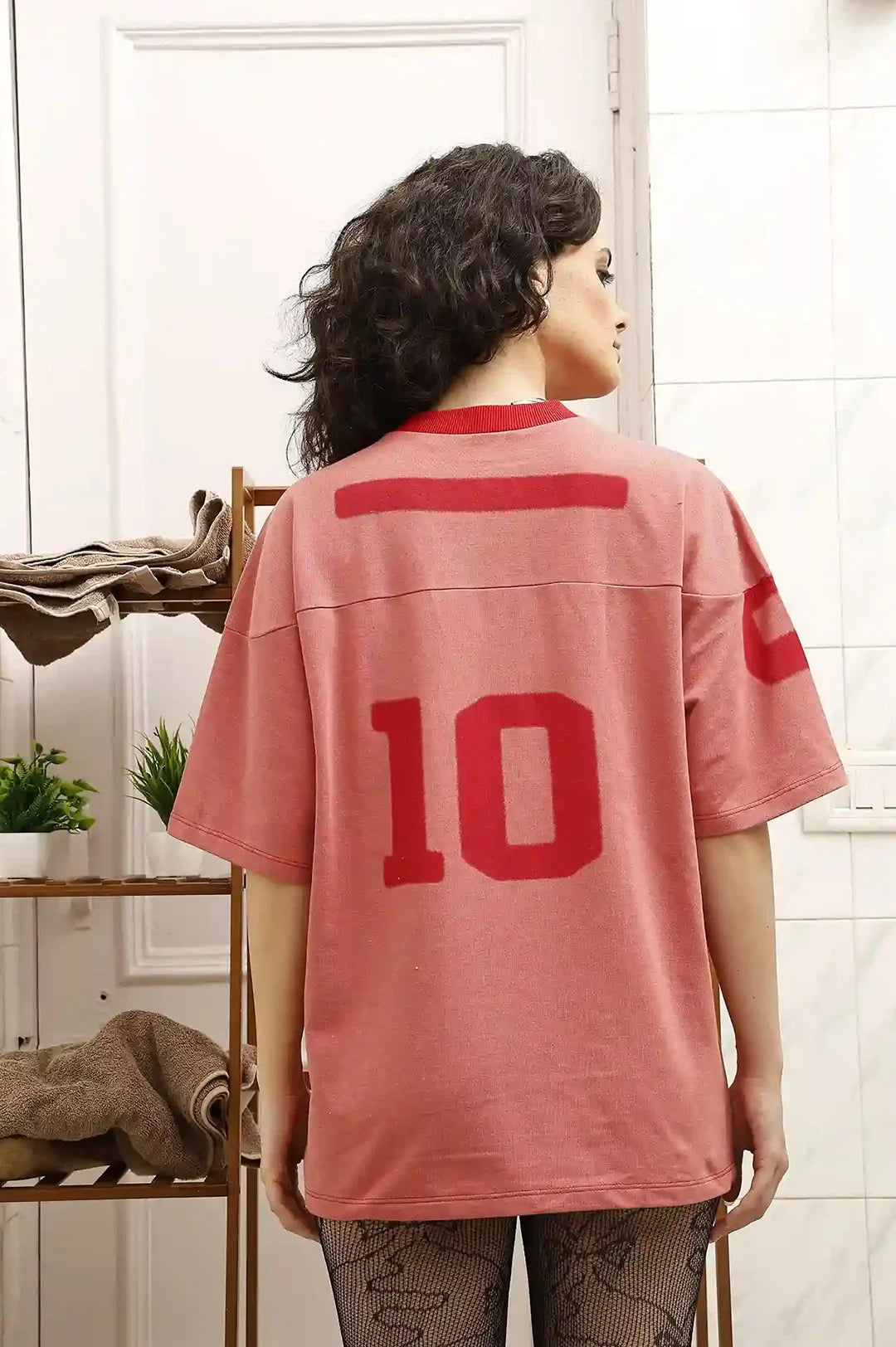 Person wearing a red sports jersey with number 10 in a room setting