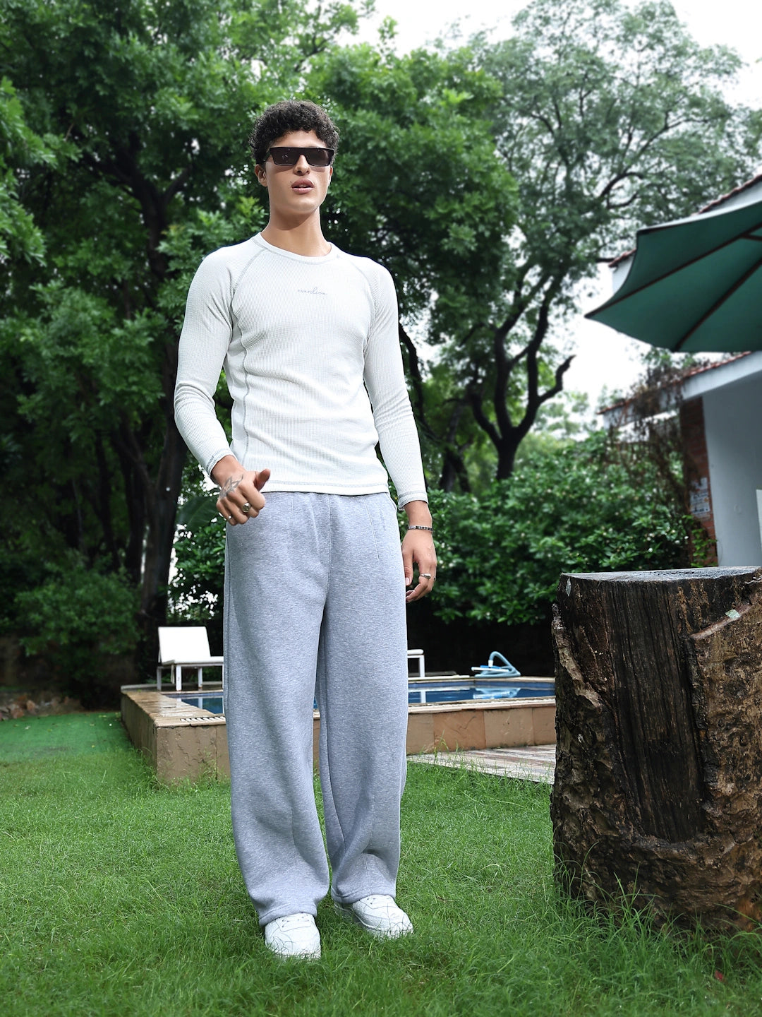 Man in a white tshirt and grey pants 