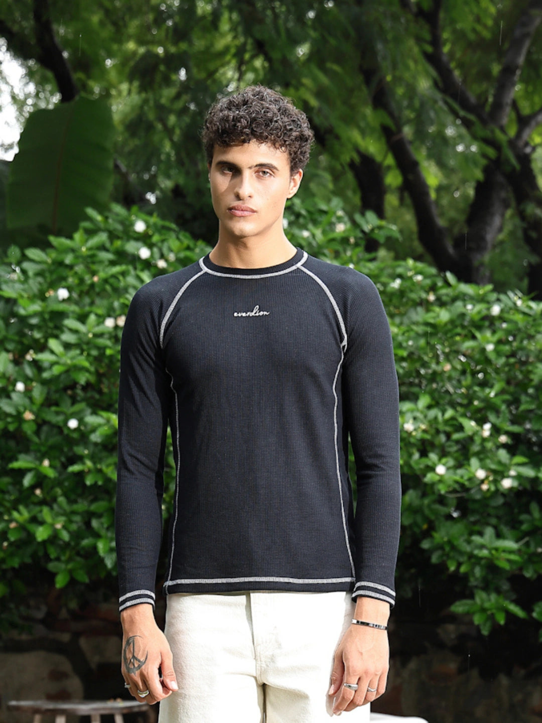 Man wearing a black long-sleeve shirt with a brand logo