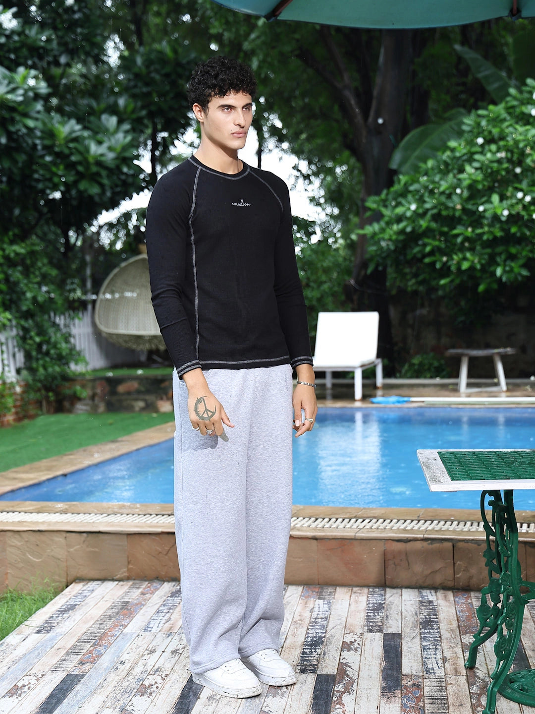 Man wearing a black long-sleeve shirt and grey pants.