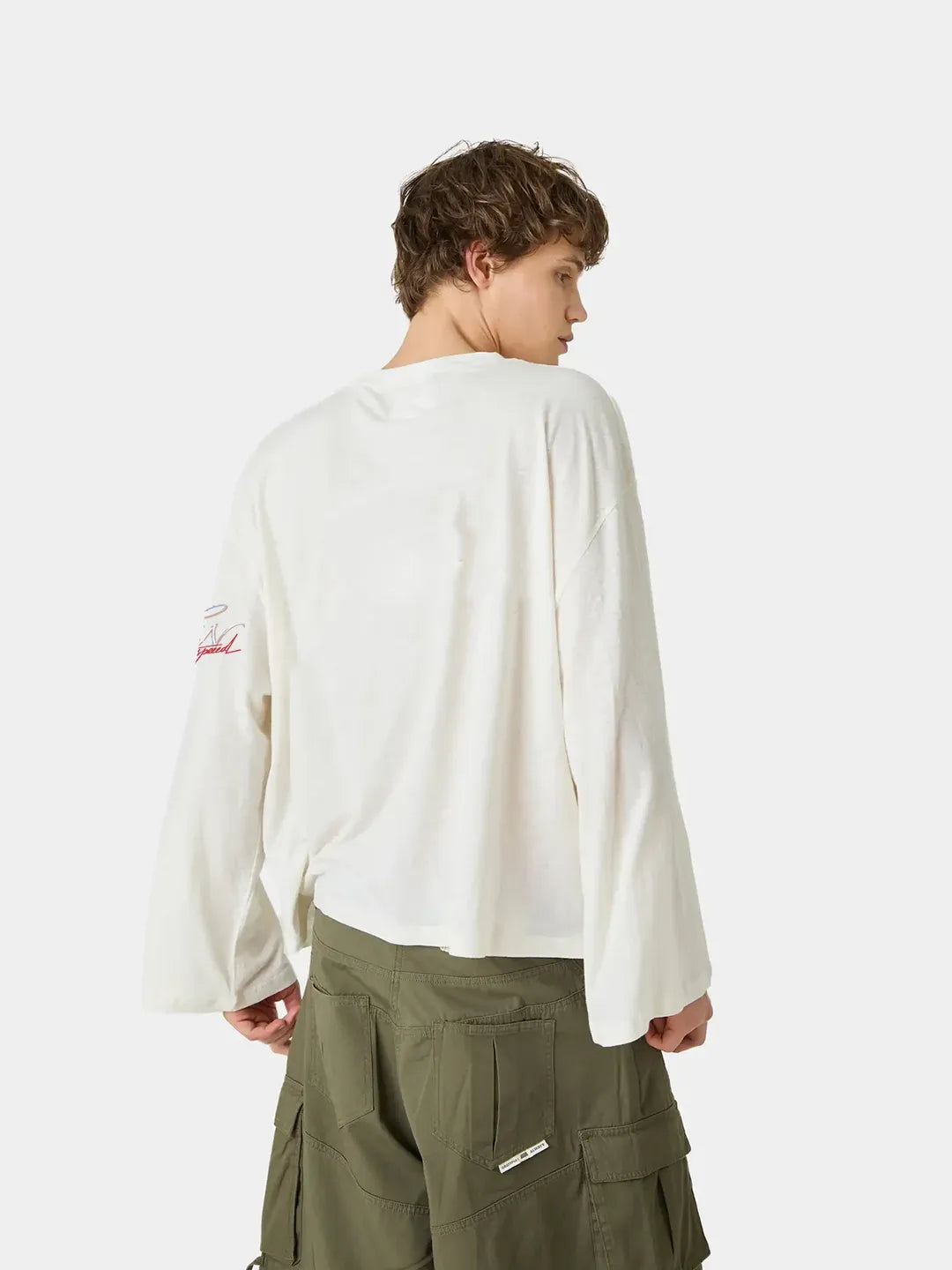 Person wearing a white long-sleeve oversized t-shirt and green cargo pants on a white background