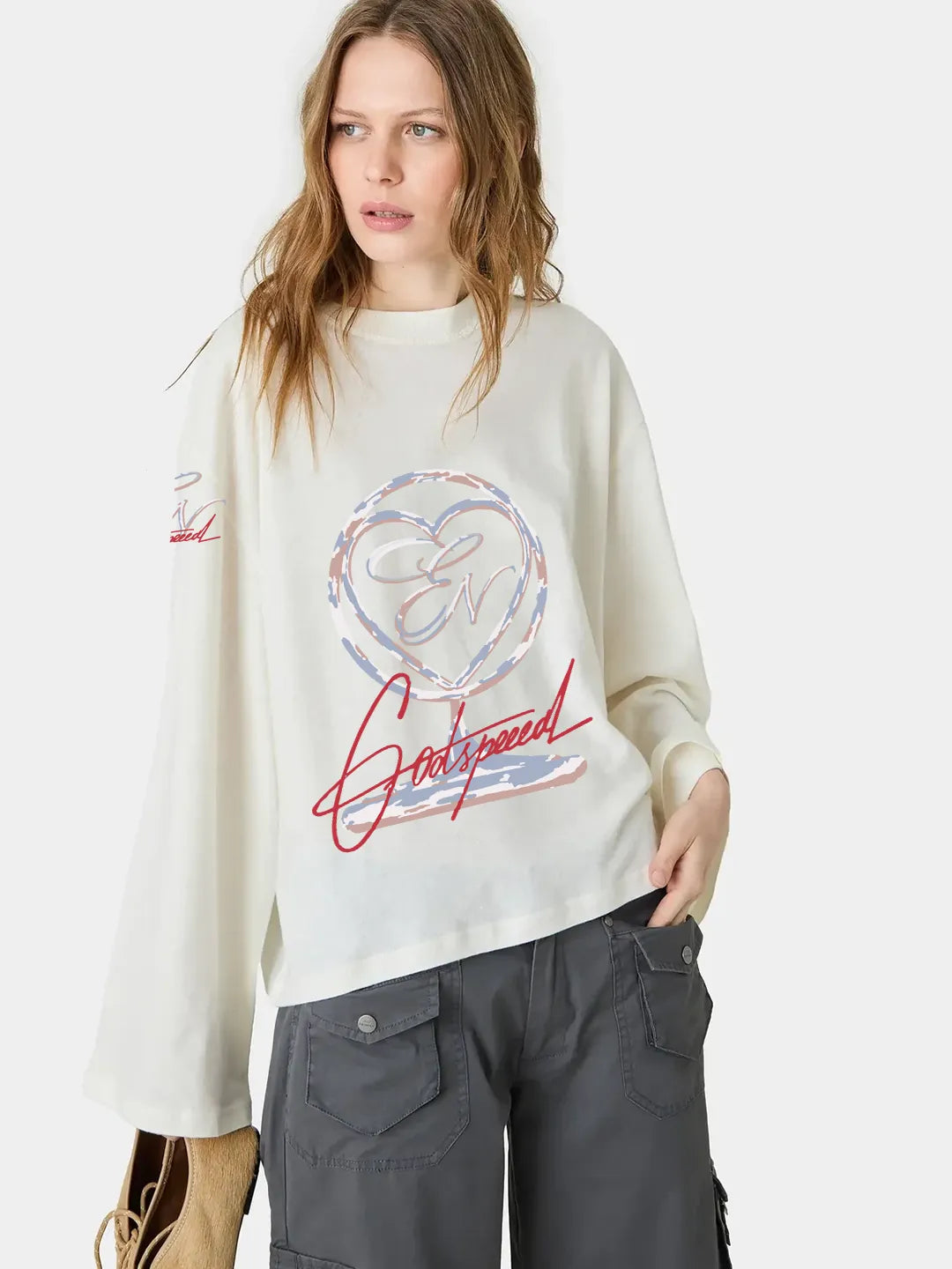 Woman wearing a white oversized t-shirt with a colorful graphic design on a plain background