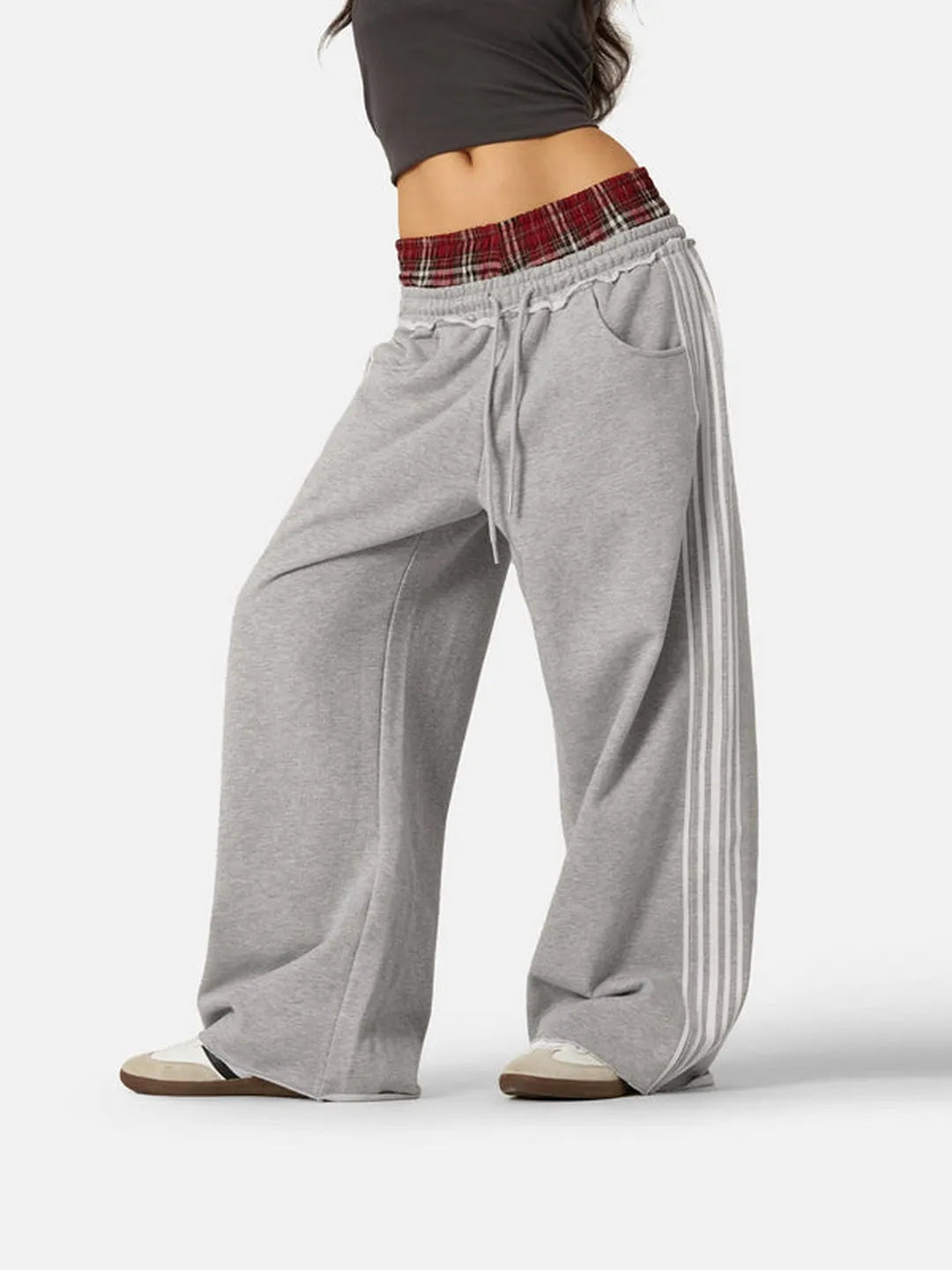 Grey sweatpants with plaid waistband on a white background