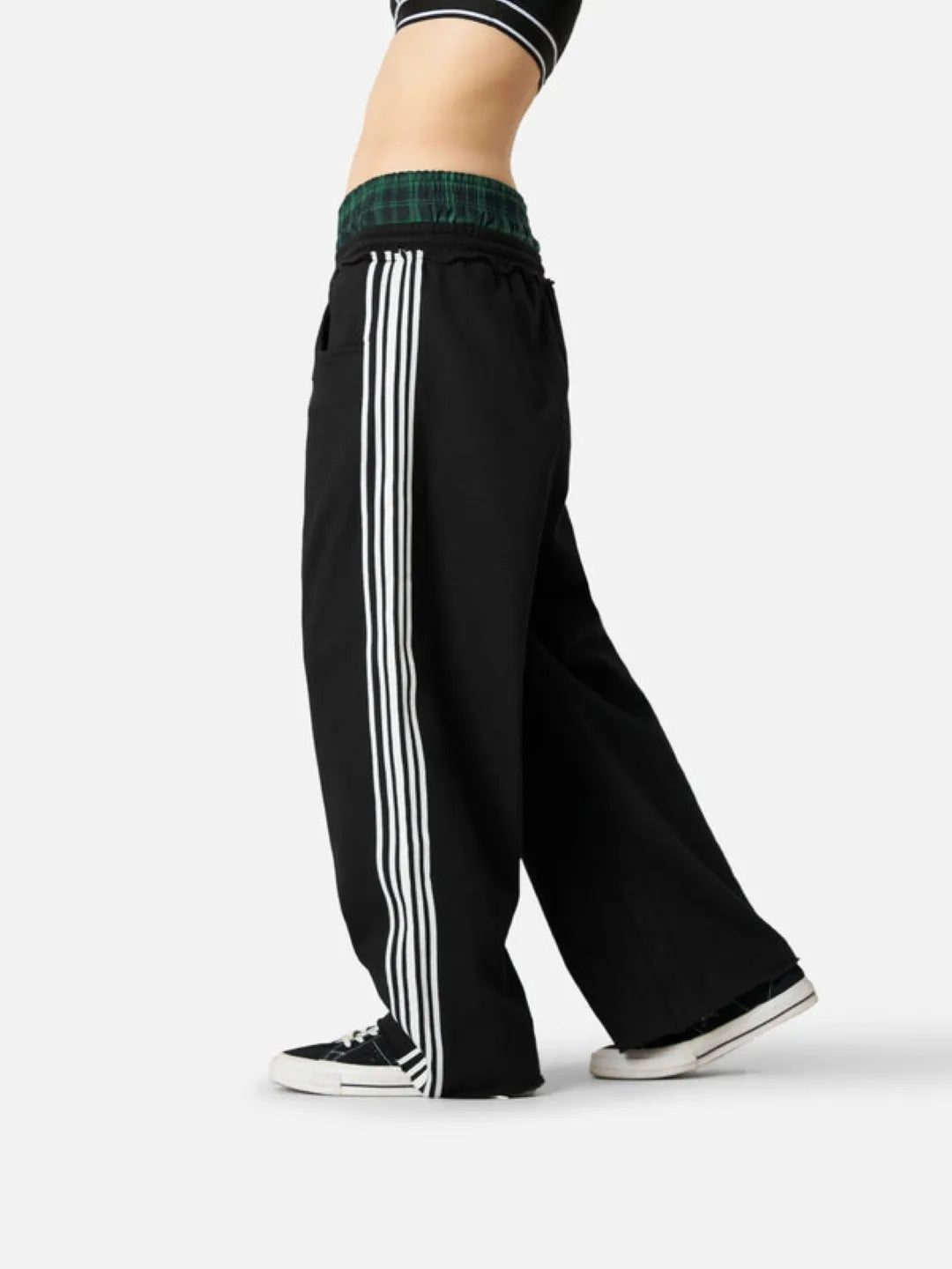 Black track pants with white stripes on a white background