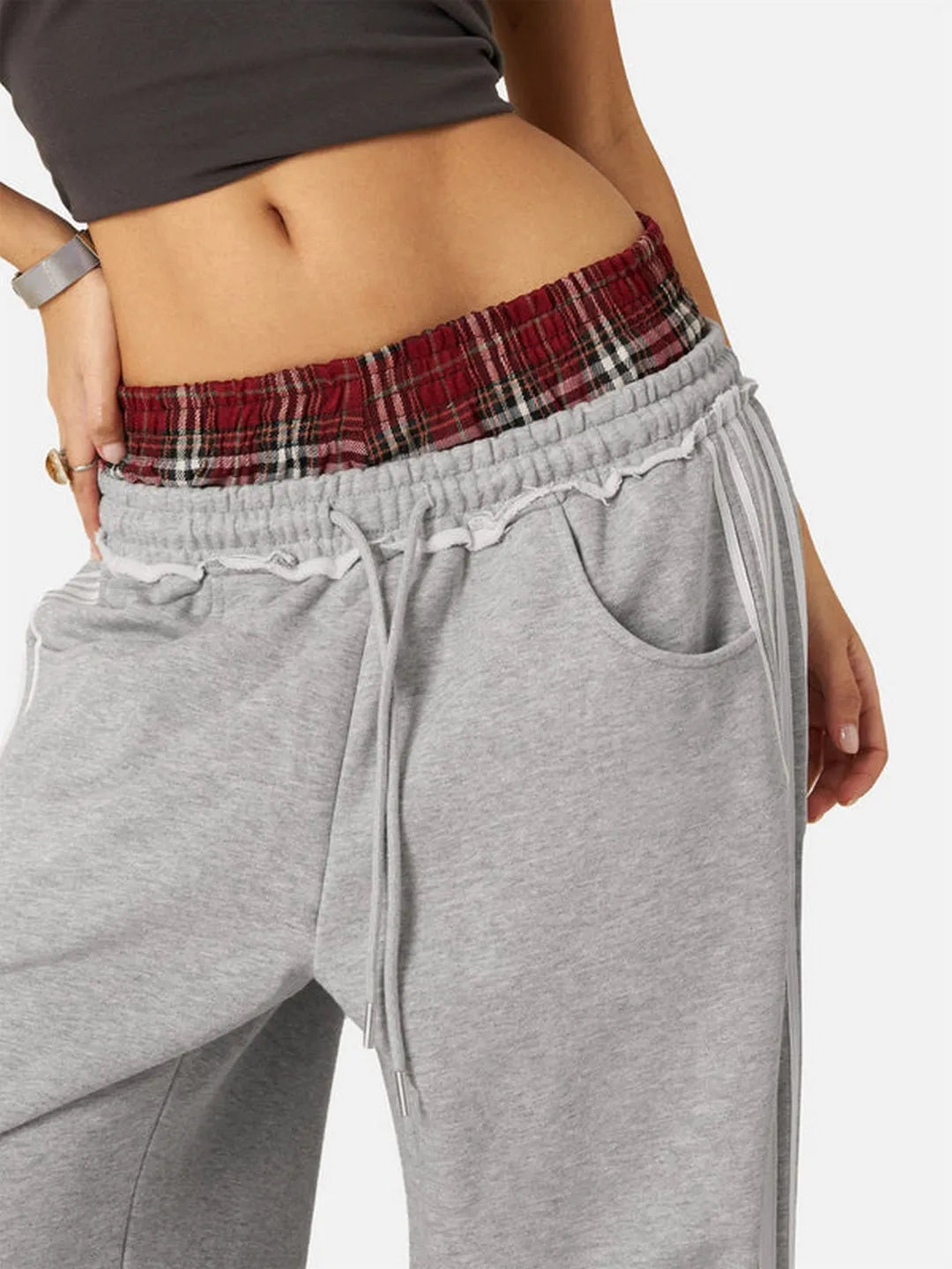Grey sweatpants with a plaid waistband on a white background