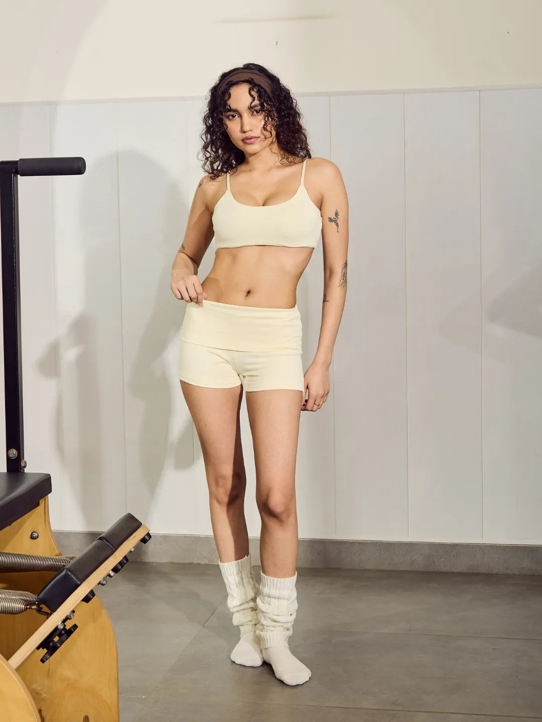 Woman in a sports bra and shorts standing in a gym setting