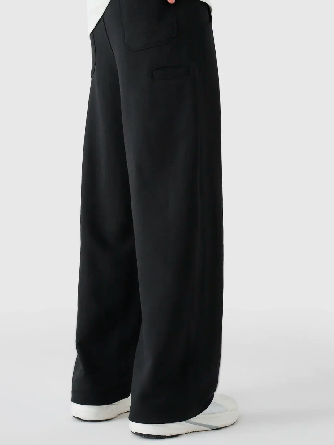 Black wide-leg pants worn by a person on a white background