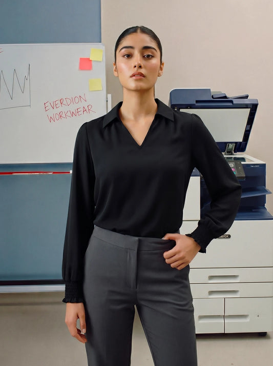 Person wearing a black shirt and grey pants in an office setting