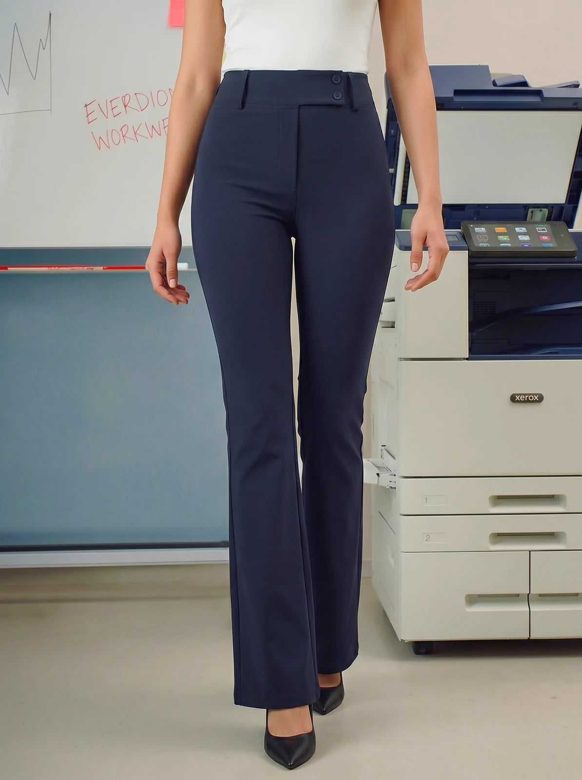 Person wearing navy blue pants standing in an office setting with a printer in the background.
